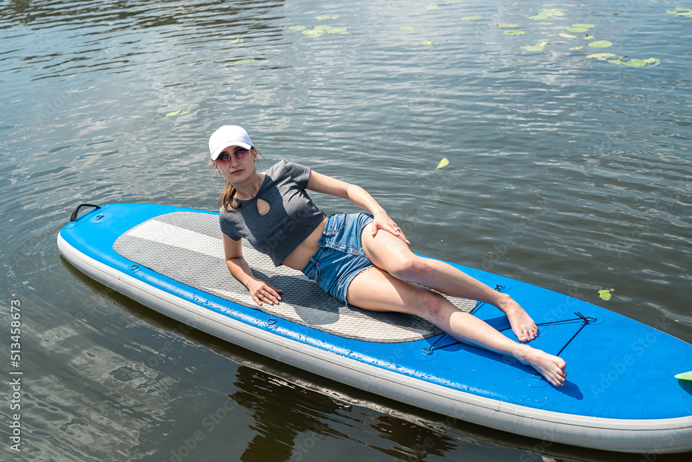 Obraz premium pretty slim woman relax on sup board in summer time, sea adventure