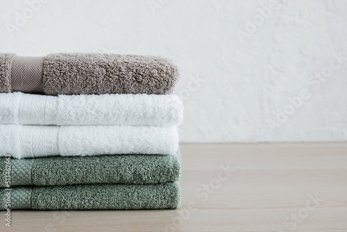 Stack of towels in bathroom on beige desk . Copy space. Minimal spa concept. Neutral colors.