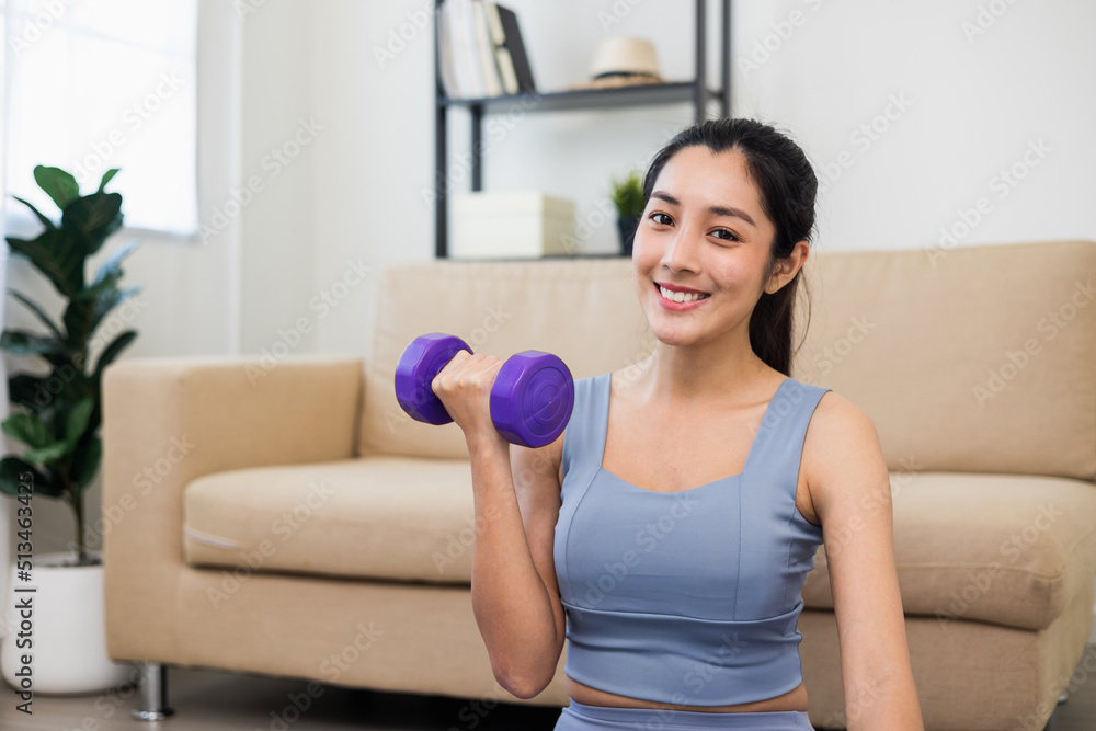 Attractive asian young fitness woman lifting dumbbell weights workout at home in living room. Fresh feeling female training and exercise wearing sport wear fit body. Attractive asian young fitness woman lifting dumbbell weights workout at home in living room. Fresh feeling female training and exercise wearing sport wear fit body.