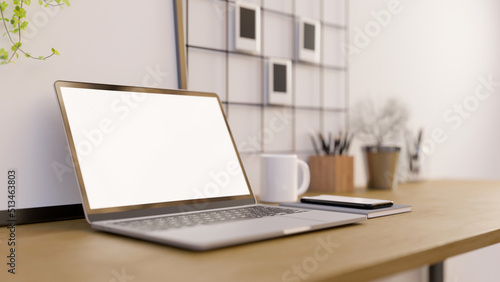 Close-up  Modern and comfortable workspace with portable laptop mockup on wood table