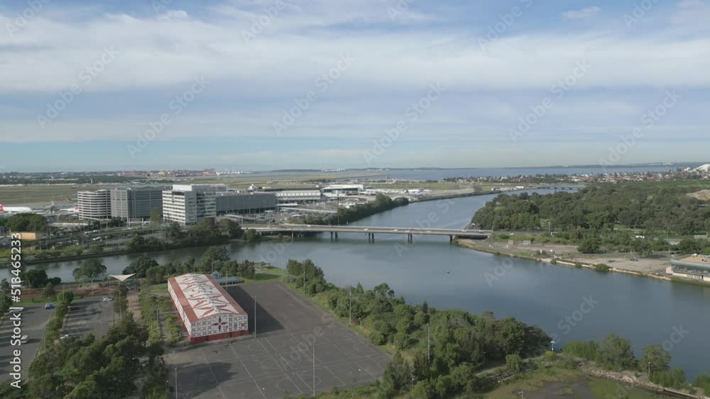Aerial zoom in view towards highway and bridge near the airport. Featuring the famous Cooks River and Sport Stadium over the public recreation park. Aerial zoom in view towards highway and bridge near the airport. Featuring the famous Cooks River and Sport Stadium over the public recreation park.
