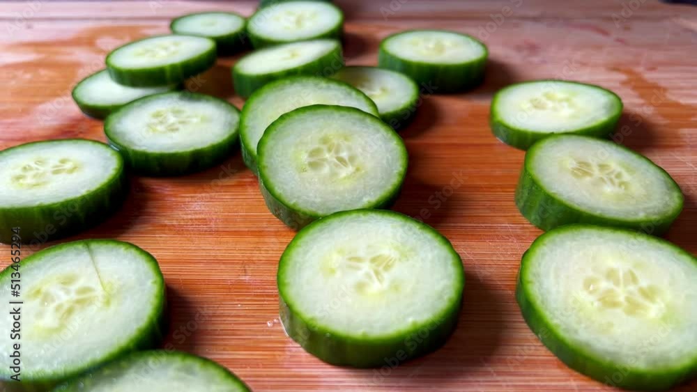 Closeup of Freshly Sliced Cucumbers On Wood Cutting Board, Slow Movement Closeup of Freshly Sliced Cucumbers On Wood Cutting Board, Slow Movement