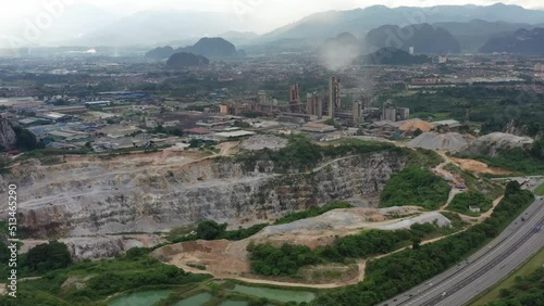 Aerial drone fly around active limestone quarrying operation and production site, destroying nature in returns of natural resources for economy purpose, at ipoh, perak state, malaysia, southeast asia. photo