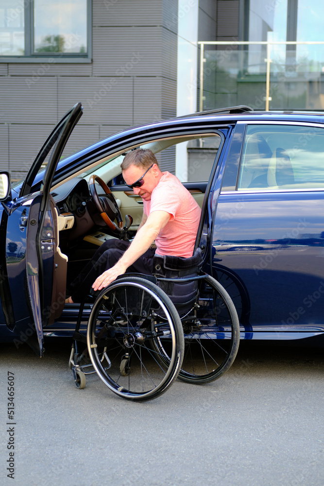 driver with disability, a man with disability unaided is ready to transfer to a wheelchair because of the steering wheel of his car