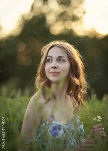 Photo of a beautiful girl in a summer meadow.