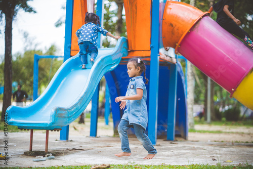 The girls enjoy playing slides in the playground.