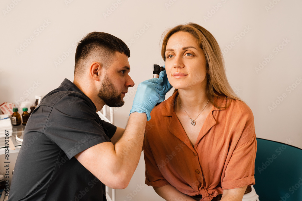 Fototapeta premium Otoscopy of ears with otoscope. ENT doctor. Consultation with otolaryngologist. Treatment of woman ear pain.