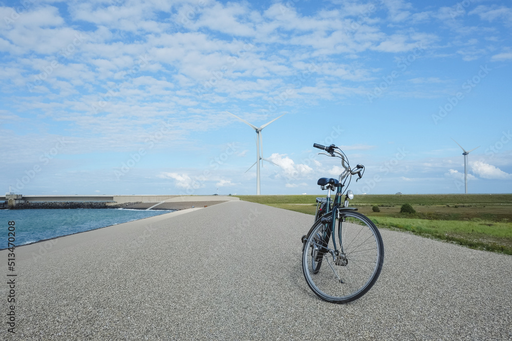 Fototapeta premium Windturbines view in Holland with elegant green bike at front