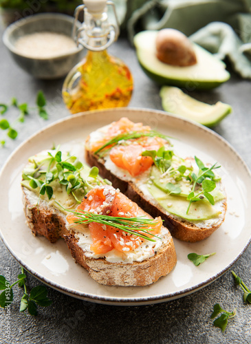 Sandwiches with salted salmon, avocado and microgreens.