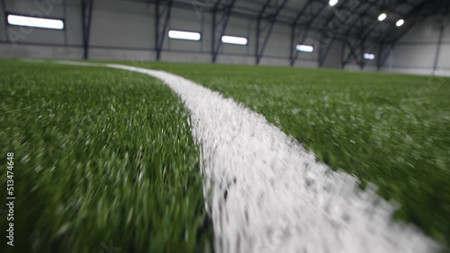 White marking line on green artificial grass of new football field in sports center extreme close view. Place for training photo