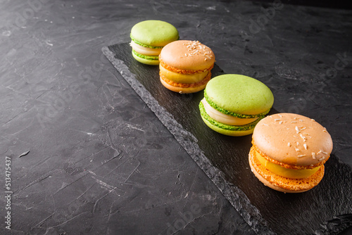 colored macaroons on a dark stone background