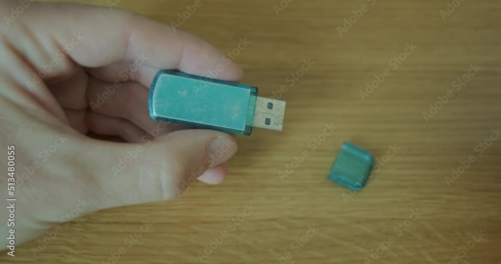 Man's hand holds flash drive, closes the connector with a protective cap. Close up Man's hand holds flash drive, closes the connector with a protective cap. Close up
