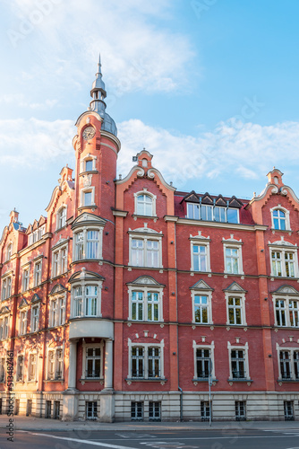 The building of the town hall from 1904. Red brick facade. Beautiful blue sky. The richly decorated facade of the tenement house. Siemianowice Śląskie, Poland