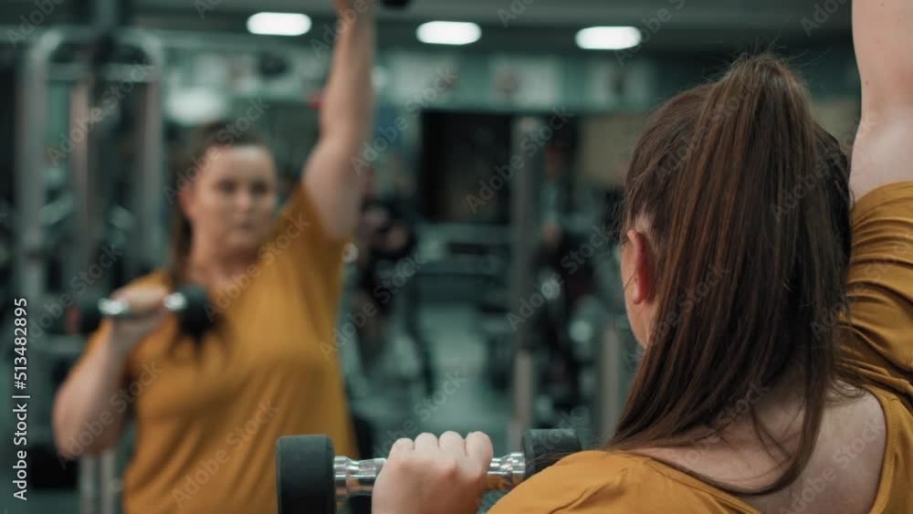 Woman with overweight doing dumbbell exercises. Shot with RED helium camera in 4K.  