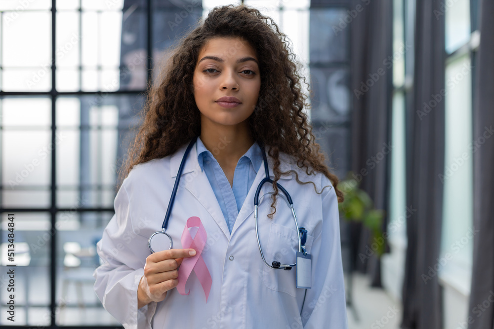 Doctor holding pink breast cancer awareness ribbon. Medicine and healthcare concept, women's health