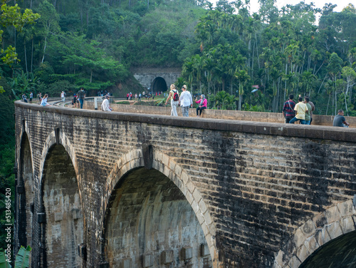 Ella, Sri Lanka - March 9, 2022: View of the nine-arch bridge, a famous place in Demodara. Tourists walk along the bridge and take pictures