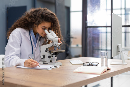 Female scientist in medicine coat works in a scientific laboratory photo
