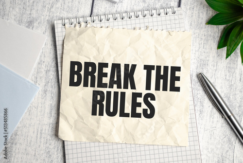 BREAK THE RULES word on the paper with office tools on white background
