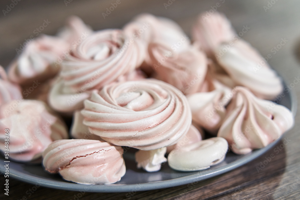pink meringues on a plate close-up, different sizes, side view pink meringues on a plate close-up, different sizes, side view