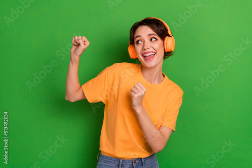 Photo of cheerful charming lady enjoy dancing listen favorite playlist isolated on green color background