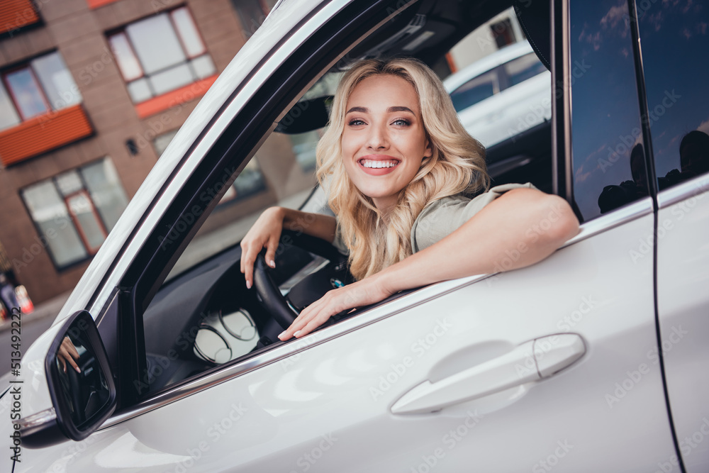 Photo of confident cheerful person sitting car front seat look through door window have good mood