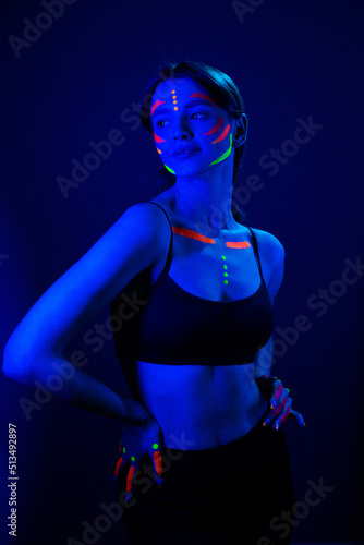 Bilde på lerret Girl with ultraviolet make-up in neon light.