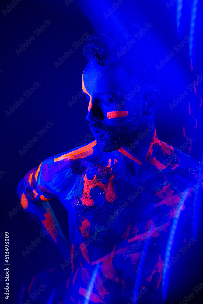 Portrait of a man with ultraviolet makeup and neon light in cyberpunk style. Portrait of a man with ultraviolet makeup and neon light in cyberpunk style.