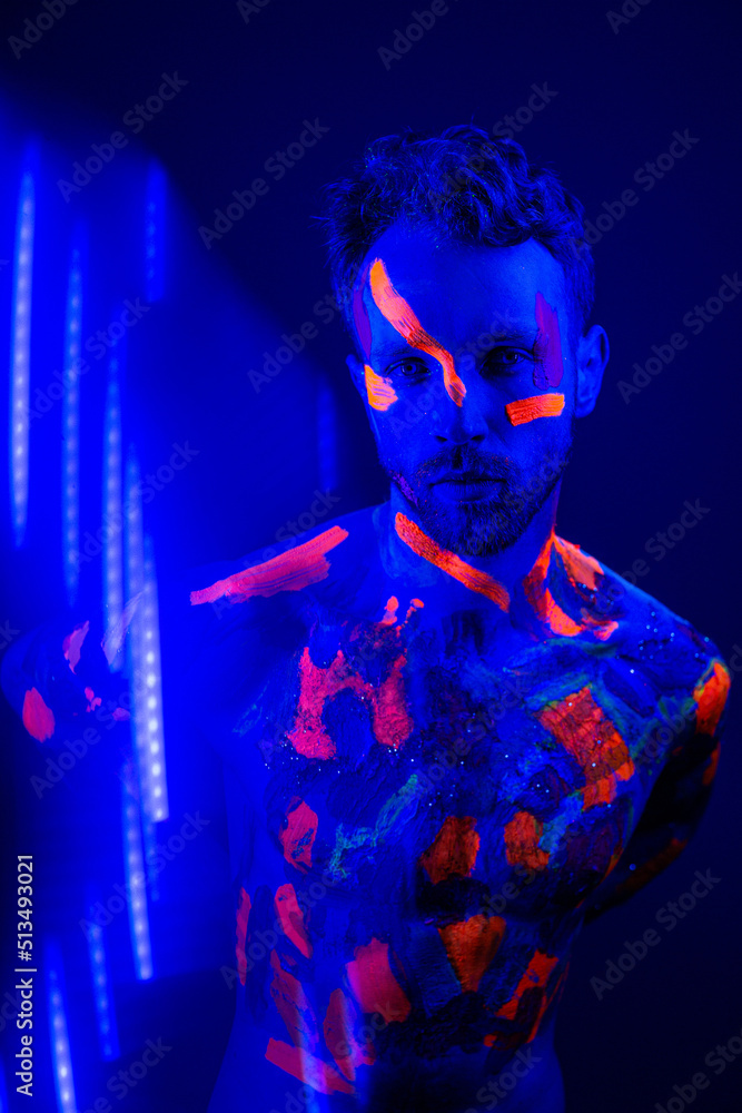 Portrait of a man with ultraviolet makeup and neon light in cyberpunk style. Portrait of a man with ultraviolet makeup and neon light in cyberpunk style.