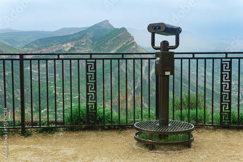 observation deck with a spotting scope over a mountain valley photo