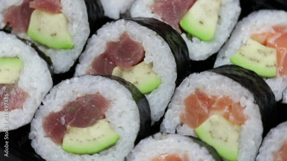 Close up sushi rolls otating. Japanese food with avocado, salmon, tuna. Close up sushi rolls otating. Japanese food with avocado, salmon, tuna.