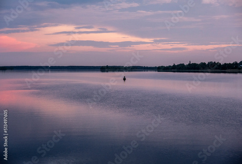 sunset on a large river with reflections in the water on a summer evening