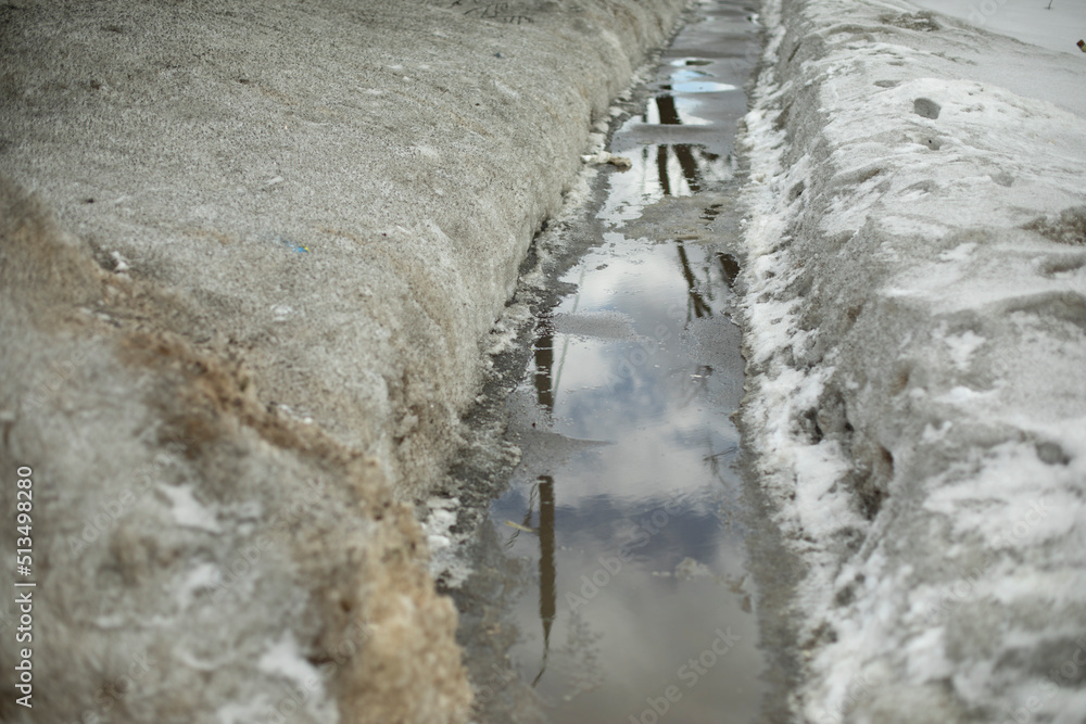 Path in water. Puddle on trail. Melting snow in city. Path in water. Puddle on trail. Melting snow in city.
