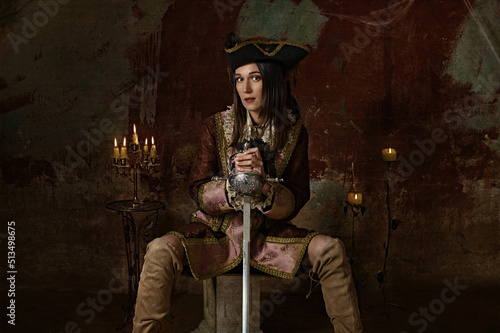 Obraz na płótnie retro portrait of a musketeer girl in a hat with a sword. w salonie