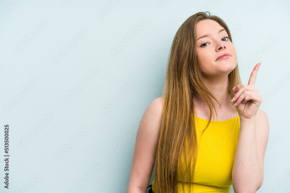 Young caucasian woman isolated on blue background showing number one with finger. Young caucasian woman isolated on blue background showing number one with finger.