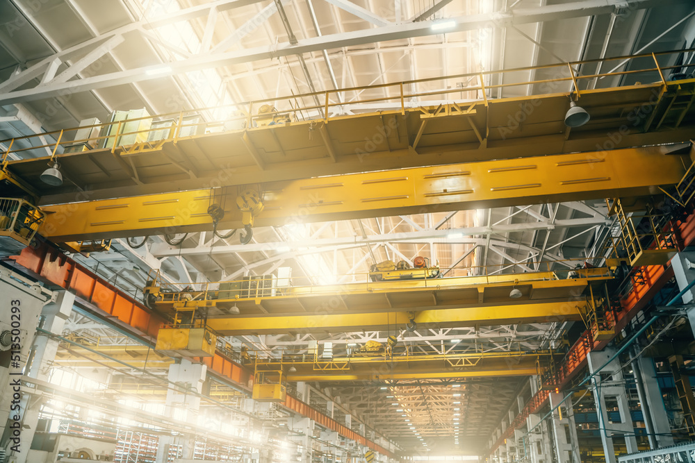 Yellow overhead or beam or bridge cranes in industrial metalworking factory. Yellow overhead or beam or bridge cranes in industrial metalworking factory.