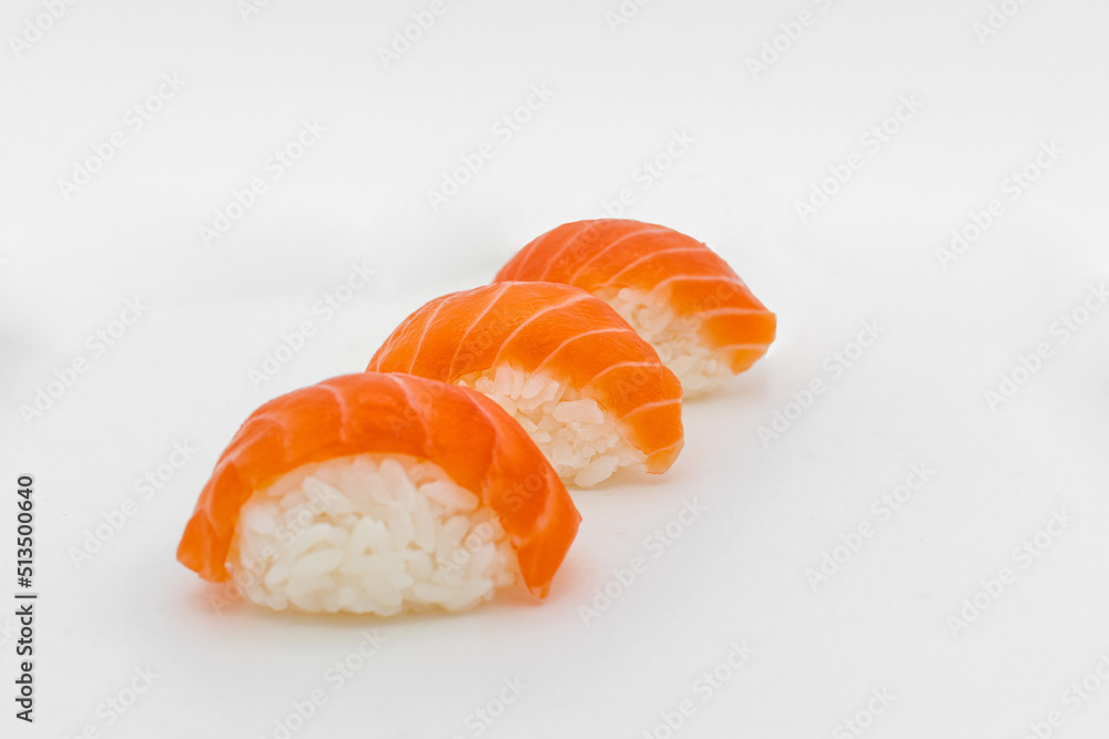 three pieces of salmon nigiri sushi on a white background three pieces of salmon nigiri sushi on a white background