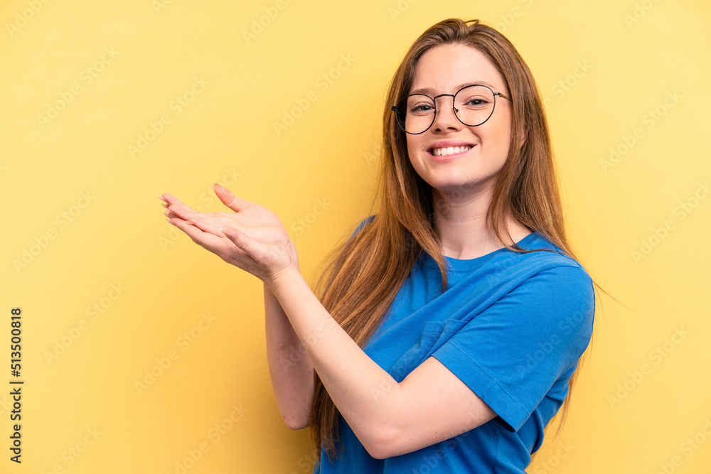 Young caucasian woman isolated on yellow background holding a copy space on a palm. Young caucasian woman isolated on yellow background holding a copy space on a palm.