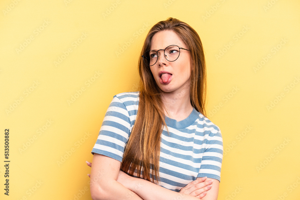 Young caucasian woman isolated on yellow background funny and friendly sticking out tongue. Young caucasian woman isolated on yellow background funny and friendly sticking out tongue.