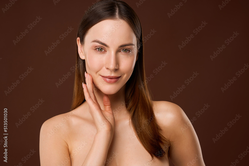 Young woman touching cheek and looking at camera Young woman touching cheek and looking at camera