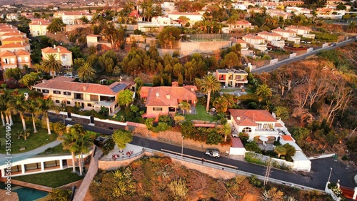 Aerial shot of beautiful mansion homes in Beverly Hills surrounded my palm trees during sunset