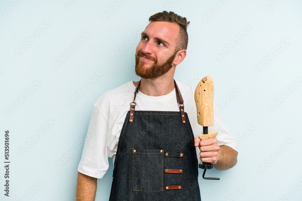 Young caucasian shoe market man isolated on blue background dreaming of achieving goals and purposes Young caucasian shoe market man isolated on blue background dreaming of achieving goals and purposes