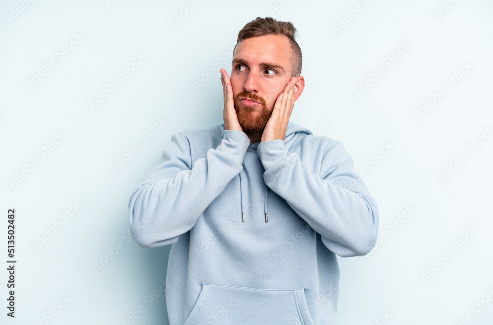 Young caucasian man isolated on blue background scared and afraid. Young caucasian man isolated on blue background scared and afraid.