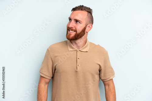 Young caucasian man isolated on blue background relaxed and happy laughing, neck stretched showing teeth. © Asier