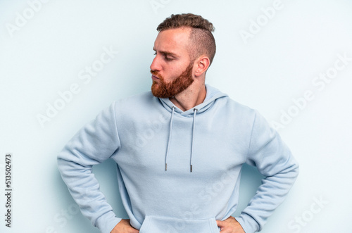 Young caucasian man isolated on blue background dreaming of achieving goals and purposes © Asier