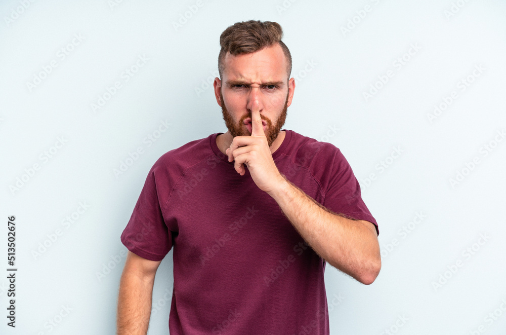 Young caucasian man isolated on blue background keeping a secret or asking for silence. Young caucasian man isolated on blue background keeping a secret or asking for silence.