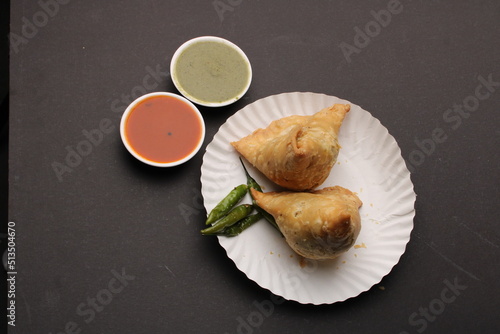 Indian favourite snack samosa served with red and green chutney
