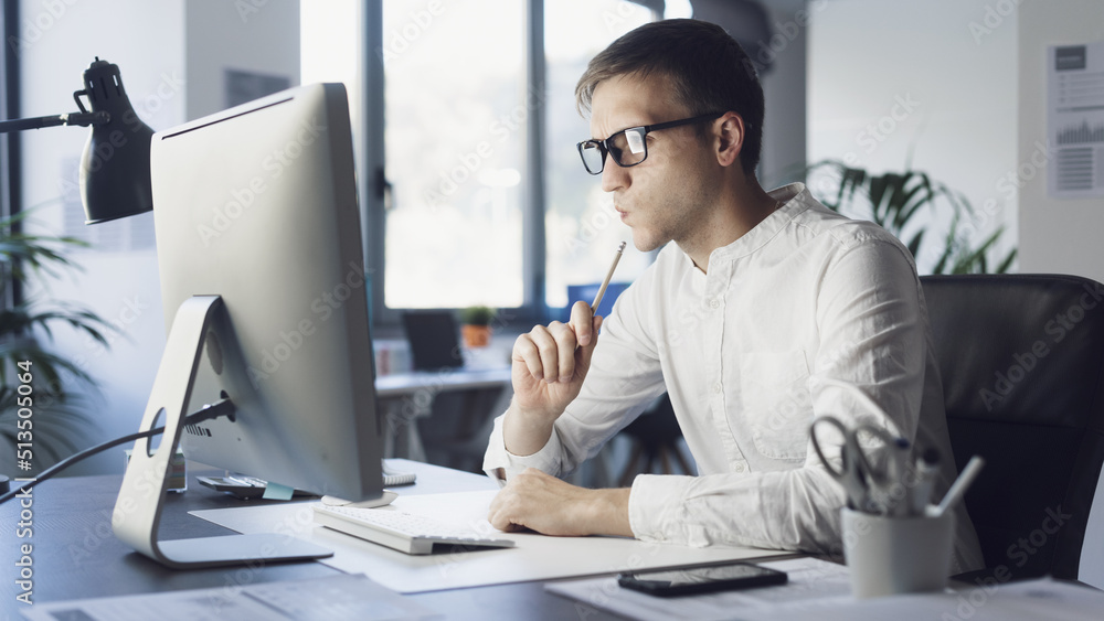 Businessman working with his computer and thinking Businessman working with his computer and thinking
