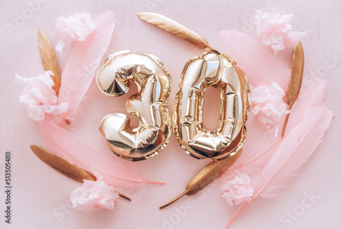 Happy thirtieth birthday with golden number thirty 30 air balloons and feathers with colorful decorations on pink