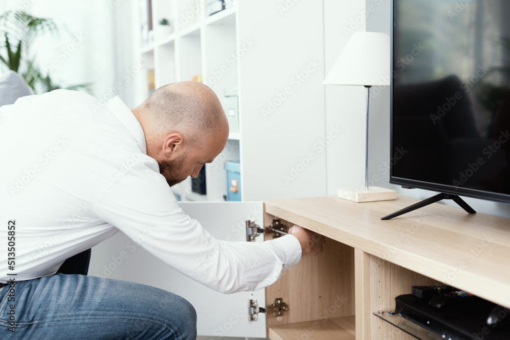 Man repairing a cabinet door hinge