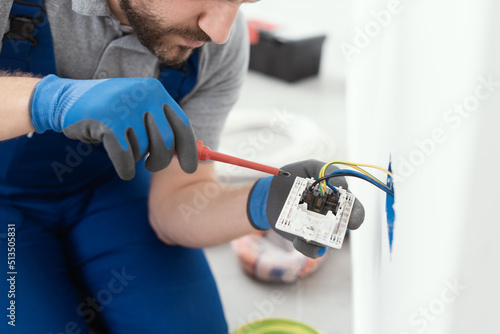 Professional electrician installing a wall socket photo